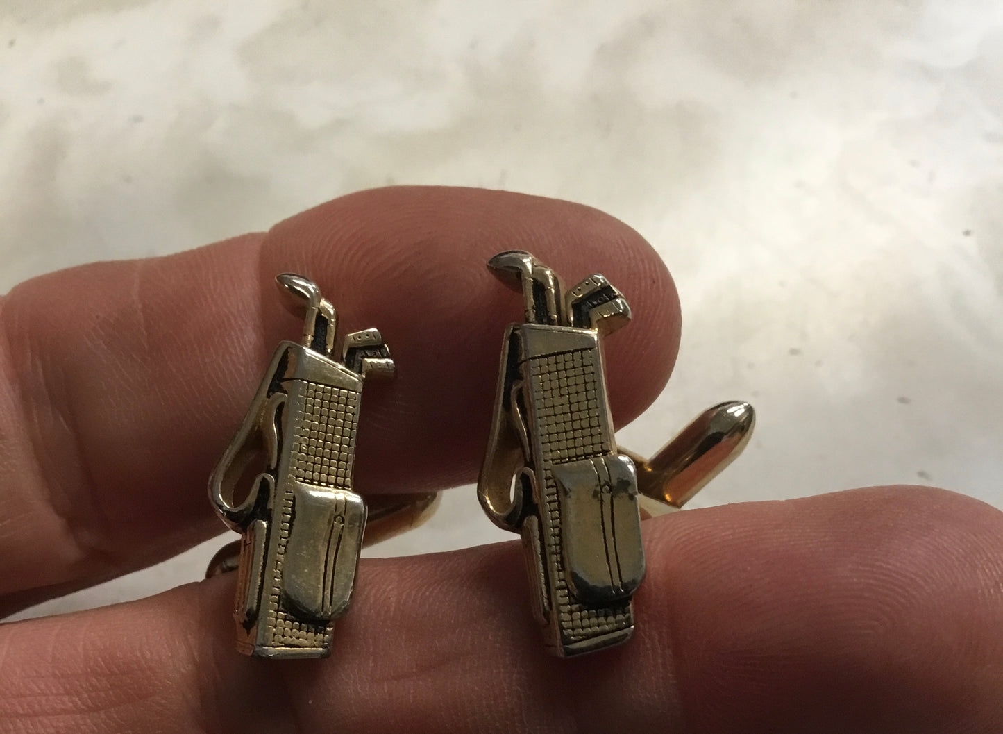 pair of vintage Swank cufflinks in the shape of a golf bag with golf clubs.