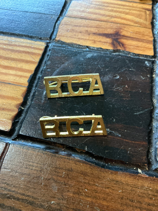 Pair RCA (Royal Canadian Artillery)Army metal shoulder titles with cotter pins.
